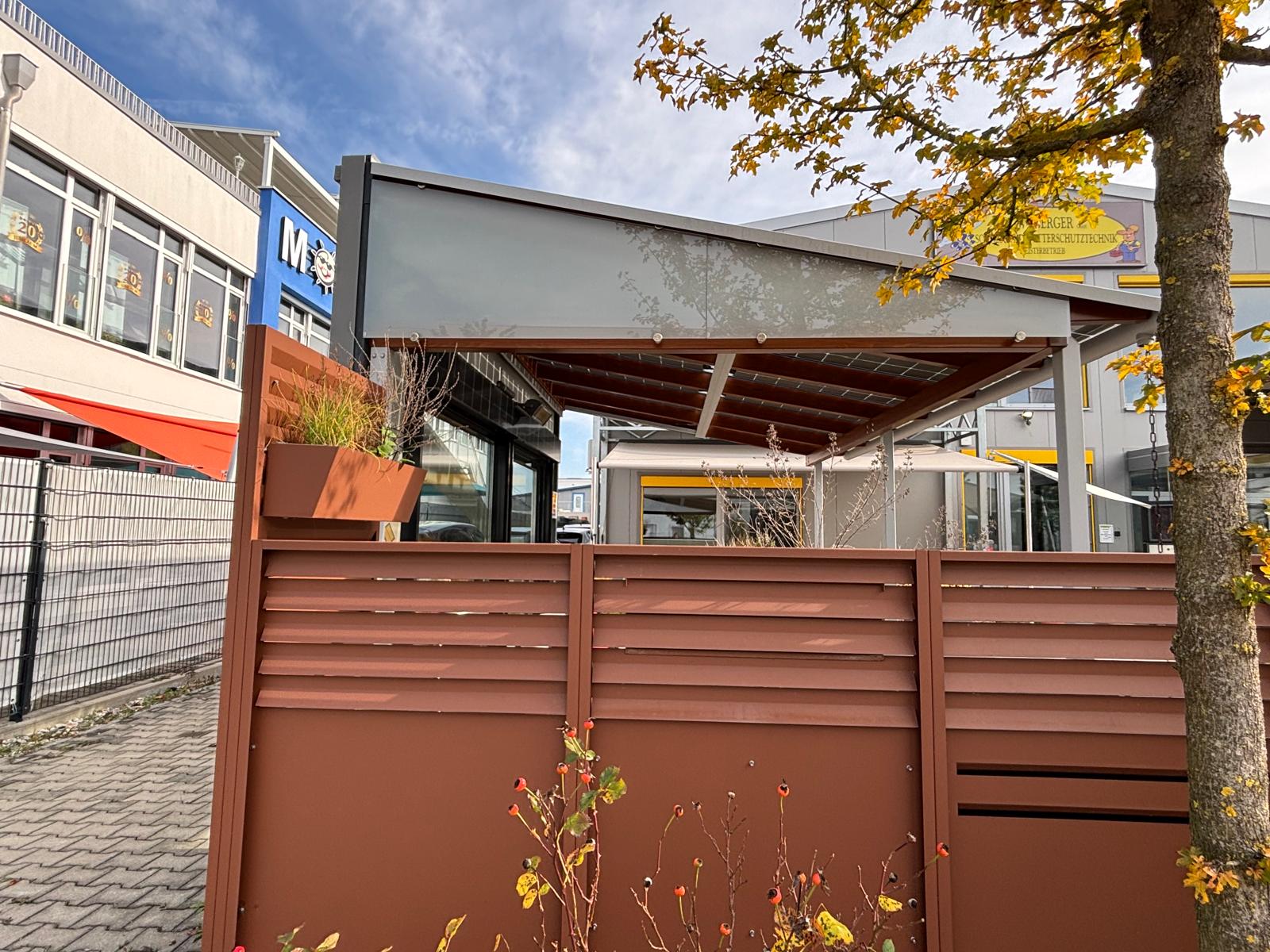 Terrassenüberdachung mit seitlichem Sichtschutz am Berger-Ausstellungsgebäude in Hallbergmoos